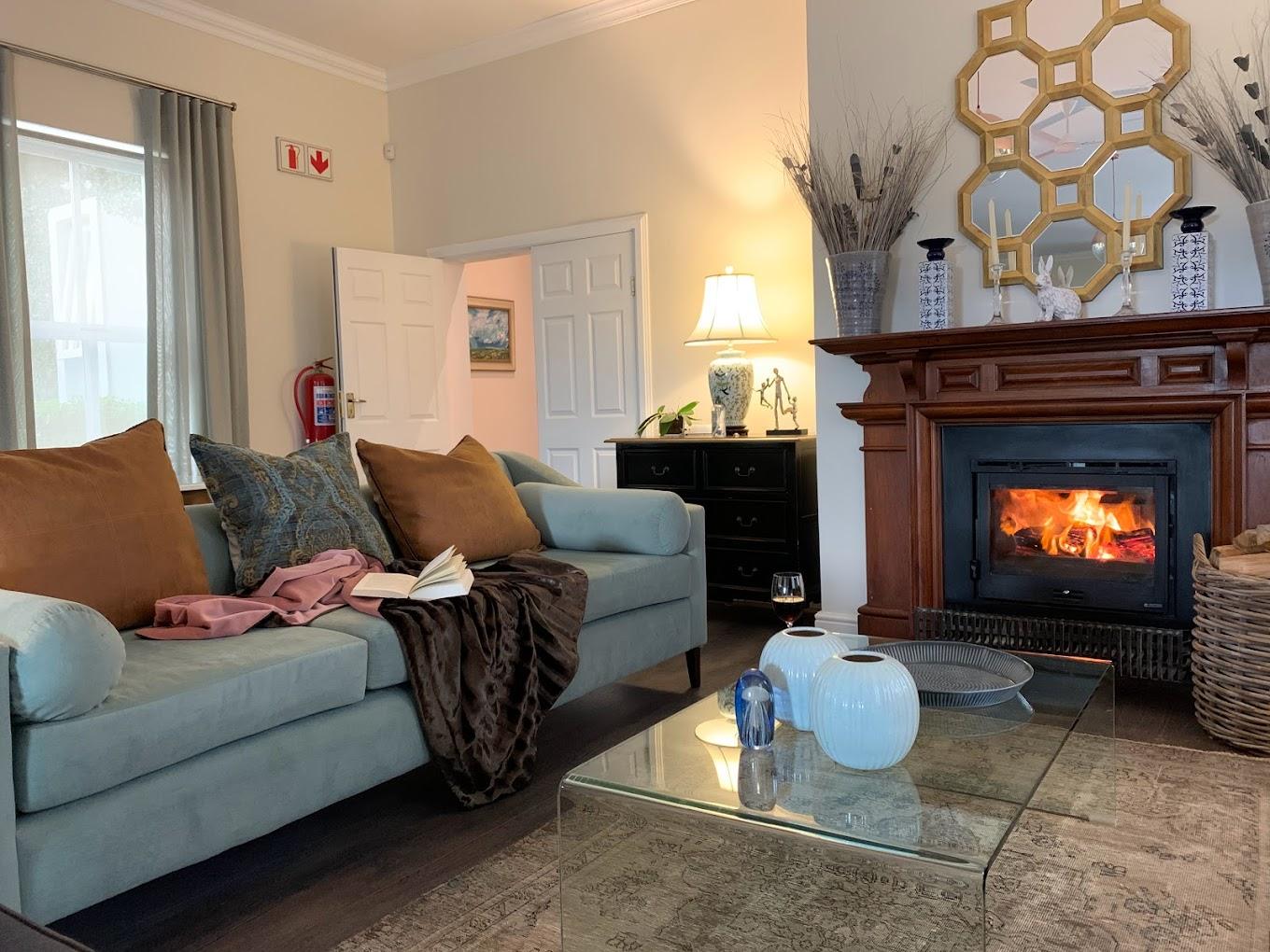 t Elegant guest lounge with a cosy fireplace at Waterstone Wines in Somerset West, offering boutique wine estate accommodation in the Helderberg, South Africa.